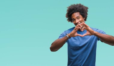 Kalp simgesi ve elleriyle şekil gösterilen aşık gülümseyen izole arka plan üzerinde Afro Amerikalı adam. Romantik kavramı.