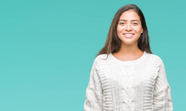 Yüzünde mutlu ve güzel bir gülümseme ile izole arka plan üzerinde kış kazak giyen genç güzel Arap kadın. Şanslı kişi.