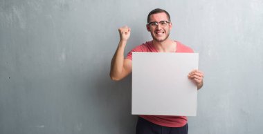 Gri grunge üzerinde beyaz delikanlı duvar boş bir afiş rahatsız tutarak ve boşa çıkarmak ile öfke, çılgın ve yükseltilmiş eliyle diye bağıran öfke kavramı bağırarak.