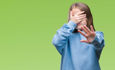 Üzerinde kış kazak giyen genç güzel kız izole elleriyle gözlerini kapsayan arka plan ve stop jest ile acı ve korku ifadesi. Utandım ve negatif kavramı.