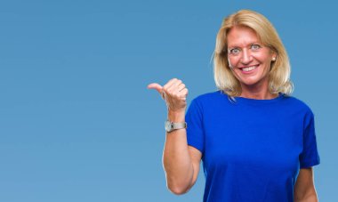 Orta yaş sarışın kadın arıyorum ve başparmak yanında yukarıyı mutlu yüz ile gülümseyen izole arka plan üzerinde.