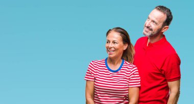 Orta yaş İspanyol çift izole arka plan uzakta yanında seyir üzerinde aşık yüzünde, doğal ifade gülümse. Kendine güvenen gülüyor.