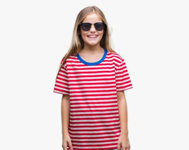 Genç güzel kız yüzünde mutlu ve güzel bir gülümseme ile izole arka plan üzerinde güneş gözlüğü takıyor. Şanslı kişi.