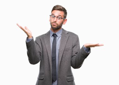 Genç yakışıklı iş adamı izole arka plan clueless ve şaşkın bir ifadeyle kollar ve eller ortaya çıkar üzerinden. Şüphe kavramı.
