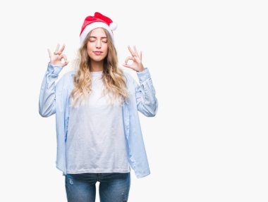 Güzel sarışın genç kadın giyen Noel şapka izole arka plan üzerinde dinlenmek ve gülümseyen gözlerle kapalı parmak jestle meditasyon yapıyor. Yoga kavramı.