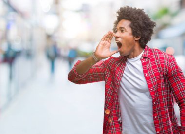 Bağırarak ve ağzı üzerinde el ile yan için çığlık izole arka plan üzerinde Afro Amerikalı adam. İletişim kavramı.