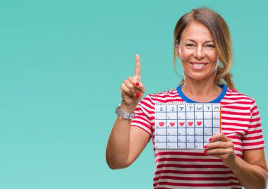 Orta yaş İspanyol kadın kıdemli holding adet izole arka bir fikirle sürpriz üzerinde takvim veya gülen yüz, bir numara ile işaret parmağı soru