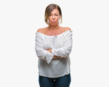 Orta yaş üst düzey İspanyol kadın izole arka plan şüpheci ve çapraz kolları olan yüzündeki gergin, onaylamayan ifade yüzünden. Negatif kişi.