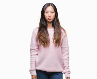 Genç Asyalı kadın yüzünde ciddi bir ifade ile izole arka plan üzerinde. Basit ve doğal kameraya bakıyor.