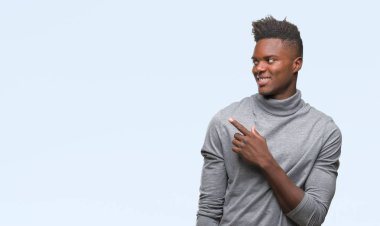 Genç Afro-Amerikan adam izole arka neşeli bir gülümseme ile el ve parmak kadar kameraya bakarak yüzündeki mutlu ve doğal ifade ile yan ile işaret yüz üzerinden.