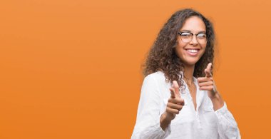 Parmak kamera ile mutlu ve komik yüz işaret eden güzel genç İspanyol kadın. İyi enerji ve vibes.