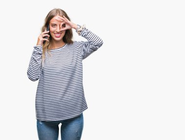 Güzel genç sarışın kadın mutlu yüz el parmaklarının arasından seyir göz üzerinde ok işaretiyle yapıyor gülümseyen izole arka plan üzerinde smarpthone üzerinde söz