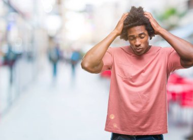 Afro Amerikalı adam çünkü umutsuz ve stresli baş ağrısı acı izole arka plan üzerinde ağrı ve migren. Ellerini kafasına.