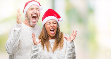 Arka plan deli kutluyor orta yaş İspanyol çift üzerinde Noel şapka izole ve crazy arms ile başarı için kaldırdı ve heyecanlı çığlık gözler kapalı. Kazanan kavramı