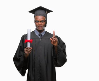 Genç Afro-Amerikan adam holding derecesi izole arka bir fikir ya da soru işaret parmağı gülen yüz, bir numara ile sürpriz üzerinde mezun oldu