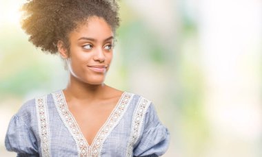 Genç afro Amerikalı kadın görünümlü yan ve dik dik bakma uzağa düşünce gülümseyen izole arka plan üzerinde.