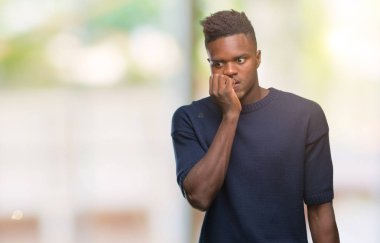 Genç Afro-Amerikan adam stresli ve gergin ile izole arka plan üzerinde tırnak ısırma dudaklarından eller. Anksiyete sorunu.