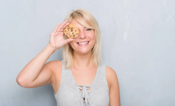 Caucásico Mujer Adulta Sobre Gris Grunge Pared Comer Chocolate Cooky —  Fotos de Stock