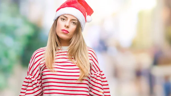 若くてきれいな女性の顔に真剣な表情で孤立した背景にクリスマス帽子をかぶっています シンプルで自然なカメラを見てください — ストック写真