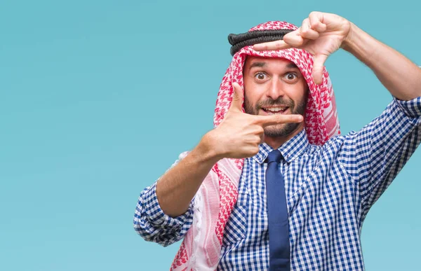Young handsome arabian business man wearing keffiyeh over isolated background smiling making frame with hands and fingers with happy face. Creativity and photography concept.