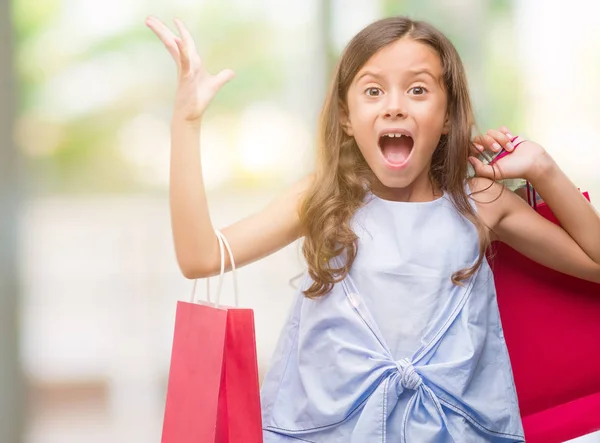 Brunette Spaanse Meisje Boodschappentassen Erg Blij Opgewonden Winnaar Expressie Vieren — Stockfoto