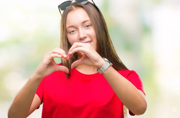 年轻美丽的白人妇女戴墨镜在孤立的背景微笑的爱显示心脏符号和形状与手 浪漫概念 — 图库照片