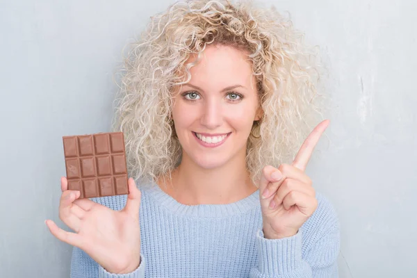 Jeune Femme Blonde Sur Mur Gris Grunge Manger Barre Chocolat — Photo