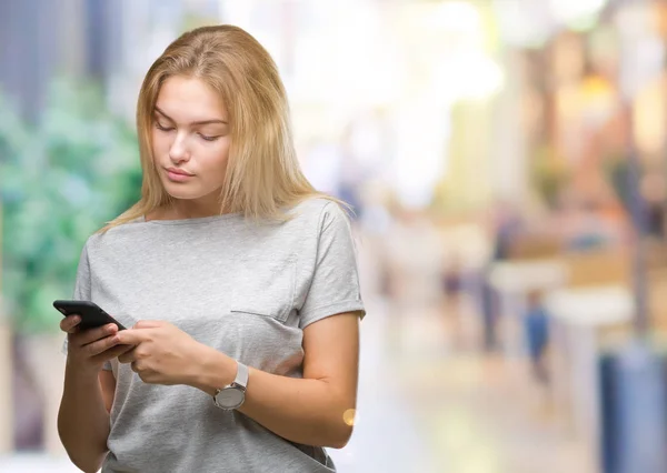 年轻的高加索妇女发送消息使用智能手机在孤立的背景与自信的表达在聪明的面孔思考严肃 — 图库照片