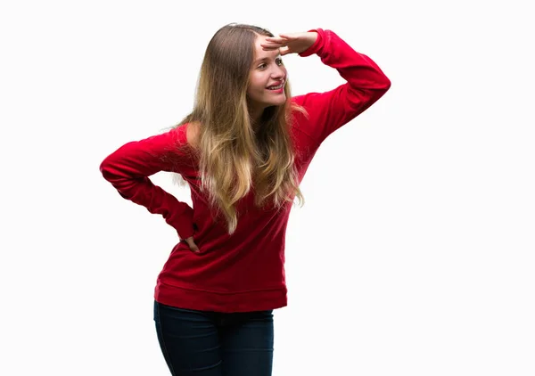 上赤いセーターを着ている若い美しいブロンドの女性は 非常に幸せと笑顔の頭上の手で遠く離れている背景を分離しました 概念を検索 — ストック写真