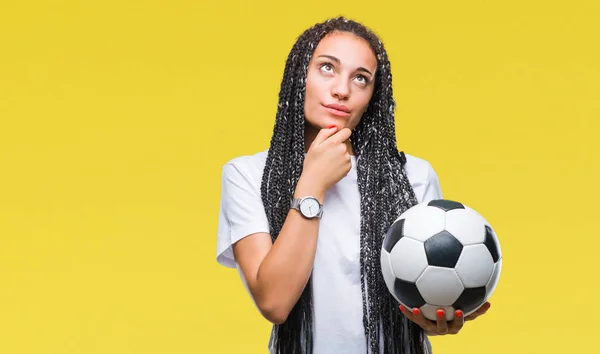 年轻的编织头发非洲裔美国女孩拿着足球在孤立的背景下严重的脸思考问题 很困惑的想法 — 图库照片