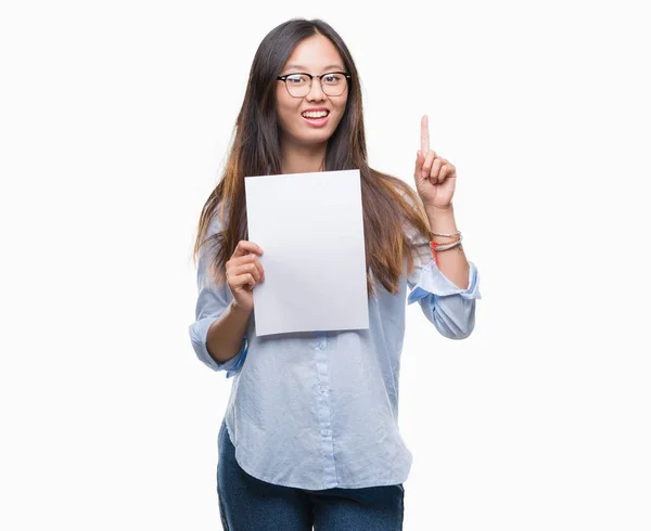 Jovem Mulher Asiática Segurando Papel Branco Sobre Fundo Isolado Surpreso — Fotografia de Stock