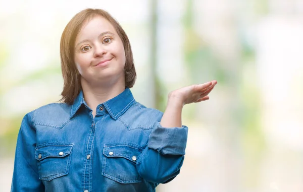 陽気な提示とカメラを見て手の手のひらで指している笑みを浮かべて分離の背景にダウン症候群の若い成人女性 — ストック写真