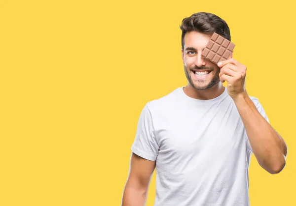 Junger Gutaussehender Mann Der Schokoriegel Vor Isoliertem Hintergrund Isst Mit — Stockfoto