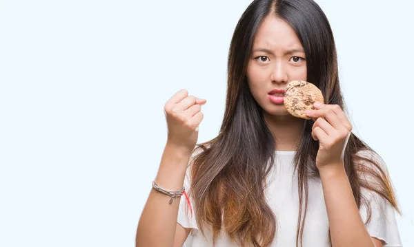 Joven Mujer Asiática Comiendo Galletas Chocolate Sobre Fondo Aislado Molesto —  Fotos de Stock