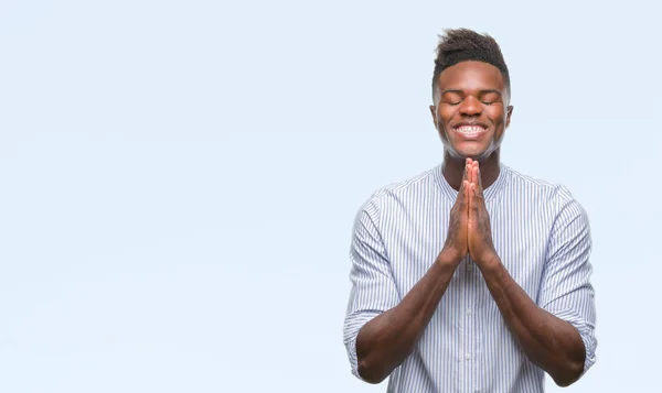 年轻的非洲裔美国人在孤立的背景祈祷双手一起请求原谅微笑自信 — 图库照片