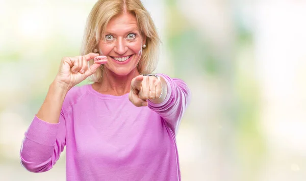 Middelbare Leeftijd Blonde Vrouw Eatin Roze Macaron Biscuit Geïsoleerde Achtergrond — Stockfoto