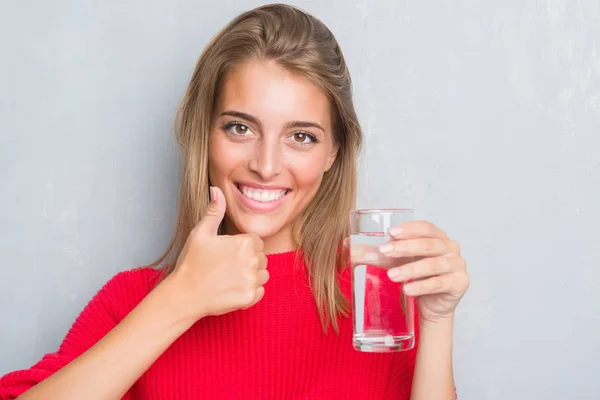 Vacker Ung Kvinna Över Grunge Grå Vägg Dricka Ett Glas — Stockfoto