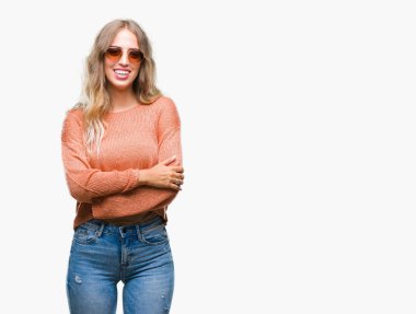 Güzel genç sarışın kadın üzerinde güneş gözlüğü takıyor mutlu yüz ile gülümseyerek kameraya seyir silah geçti arka plan izole. Olumlu bir kişi.