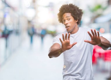 Şokta bağırarak Afro Amerikan adam izole arka plan korkuyor ve korku ifade dur hareketi el ile ile çok korkmuş. Panik kavramı.