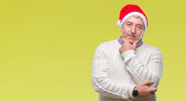 Yakışıklı komuta sizde emin çapraz kollar ve çeneme kaldırdı el ile gülümseme ile kameraya bakarak izole arka plan üzerinde Noel şapka giyiyor. Pozitif düşünce.