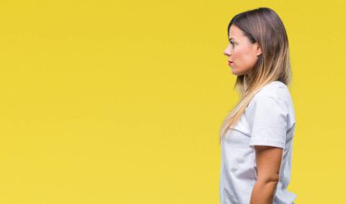 Genç güzel kadın rahat beyaz t-shirt üzerine arka tarafına, seyir izole dinlenmek doğal yüz emin gülümseme ile pozuyla profili.