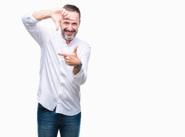 Orta yaş elle yapma çerçeve ve parmakları ile mutlu yüz gülümseyen izole arka plan üzerinde ağarmış komuta sizde. Yaratıcılık ve Fotoğrafçılık kavramı.