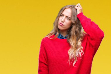 Güzel sarışın genç kadın giyiyor kış kazak izole arka plan üzerinde yanıltır ve soru hakkında merak ediyorum. Şüphe, kafasına el ile düşünme ile belirsiz. Dalgın kavramı.