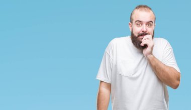 Stresli ve gergin elle çivi ısırma ağzına bakarak izole arka plan üzerinde rahat t-shirt giyen genç beyaz hipster adam. Anksiyete sorunu.
