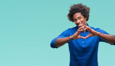 Kalp simgesi ve elleriyle şekil gösterilen aşık gülümseyen izole arka plan üzerinde Afro Amerikalı adam. Romantik kavramı.