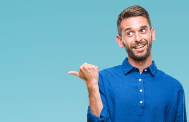 Yakışıklı delikanlı arıyor ve başparmak yanında yukarıyı mutlu yüz ile gülümseyen izole arka plan üzerinde.