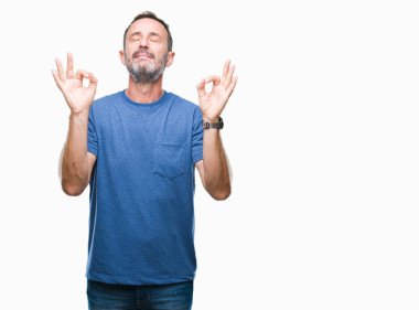 Orta yaş ağarmış komuta sizde izole arka plan üzerinde dinlenmek ve gülümseyen gözlerle kapalı parmak jestle meditasyon yapıyor. Yoga kavramı.