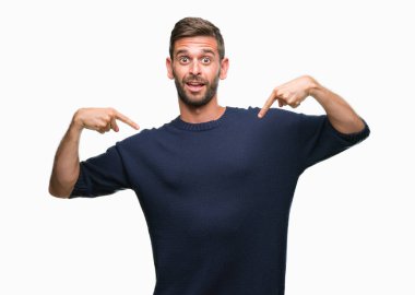 Yüzünde gülümseme ile kendinden emin görünüyorsun, kendini gururlu ve mutlu parmakları ile işaret izole arka plan üzerinde kış kazak giyen genç yakışıklı adam.