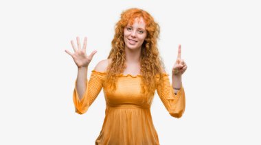 Gösterilen ve parmakları ile işaret genç Kızıl saçlı kadın kendinden emin ve mutlu gülümseyerek süre 6 numara.