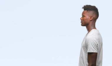 İzole arka tarafına, arayan genç Afro-Amerikan adam sakin ol kendine güvenen gülümseme ile doğal yüz pozuyla profili.